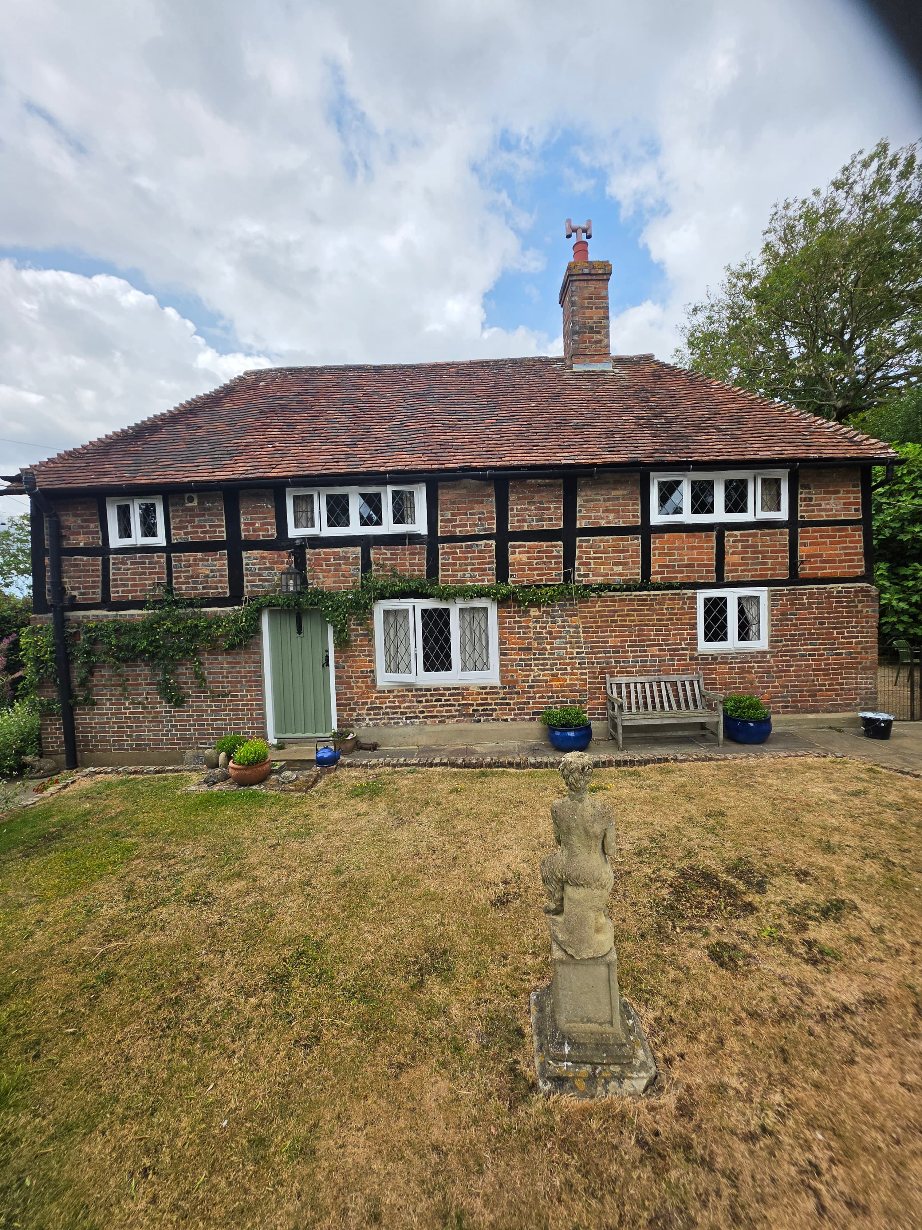 Exterior painting of a period cottage — windows and front door finished by PJW Decorators
